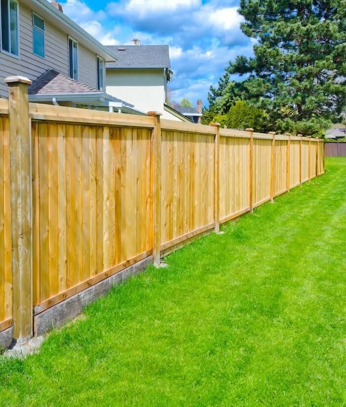 A wooden fence surrounds a lush green lawn in front of a house — Machin's Sawmill Pty Ltd In Wingham, NSW