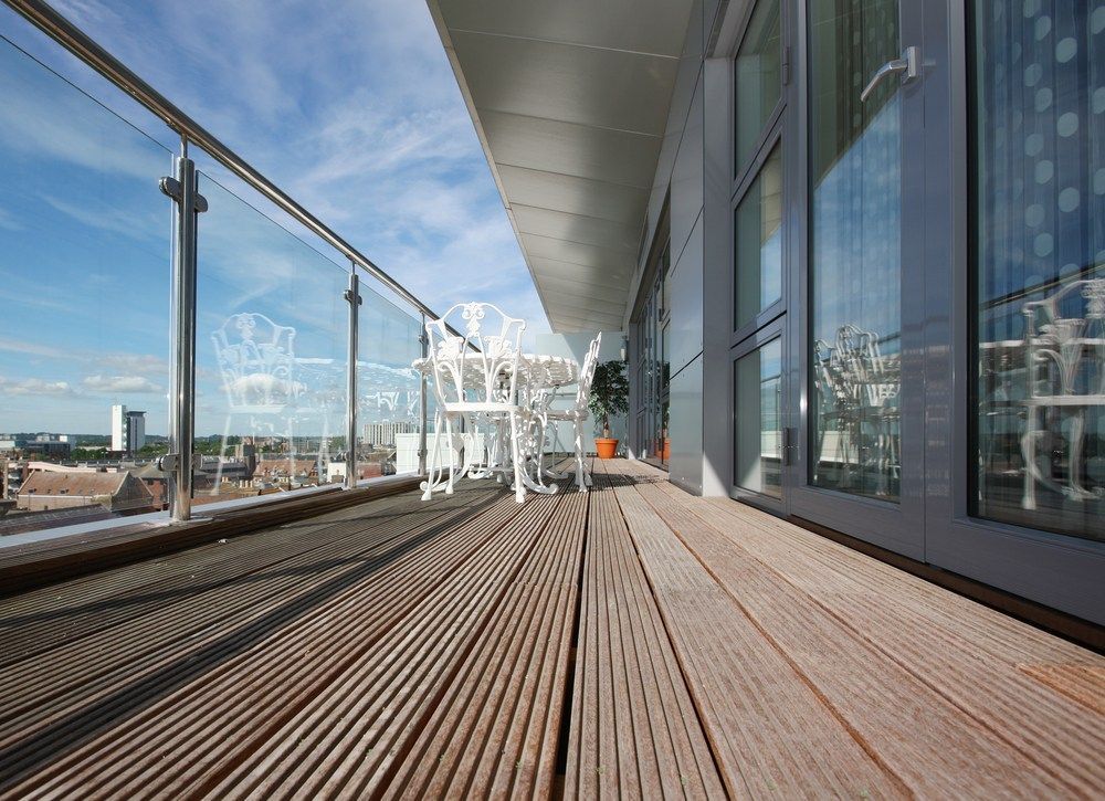 A Balcony With A Wooden Deck And A Glass Railing — Machin's Sawmill Pty Ltd In Maitland, NSW