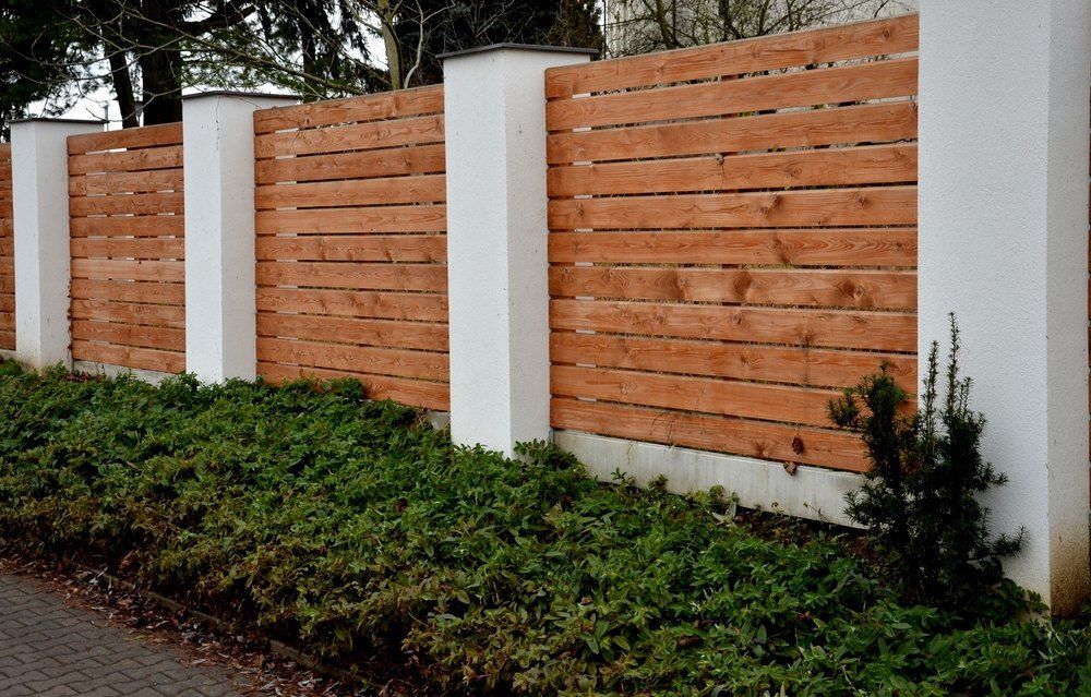 A Wooden Fence Is Surrounded By White Pillars And Bushes — Machin's Sawmill Pty Ltd In Maitland, NSW