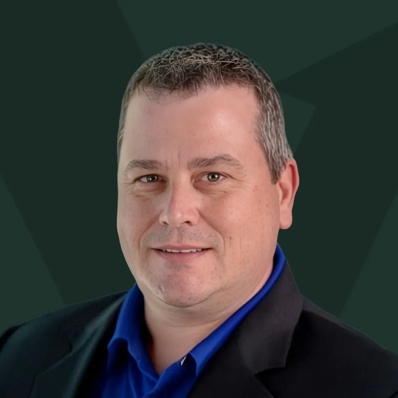 Portrait of a man in a dark blazer and blue shirt against a green geometric background