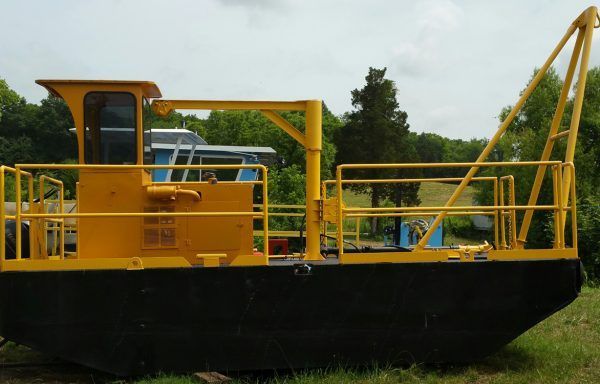 A crane is lifting a large piece of concrete over a body of water