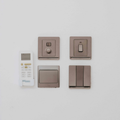 Wall-mounted switches and a remote control on a white wall