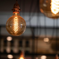 Close-up of a glowing vintage Edison bulb hanging indoors against a blurred background