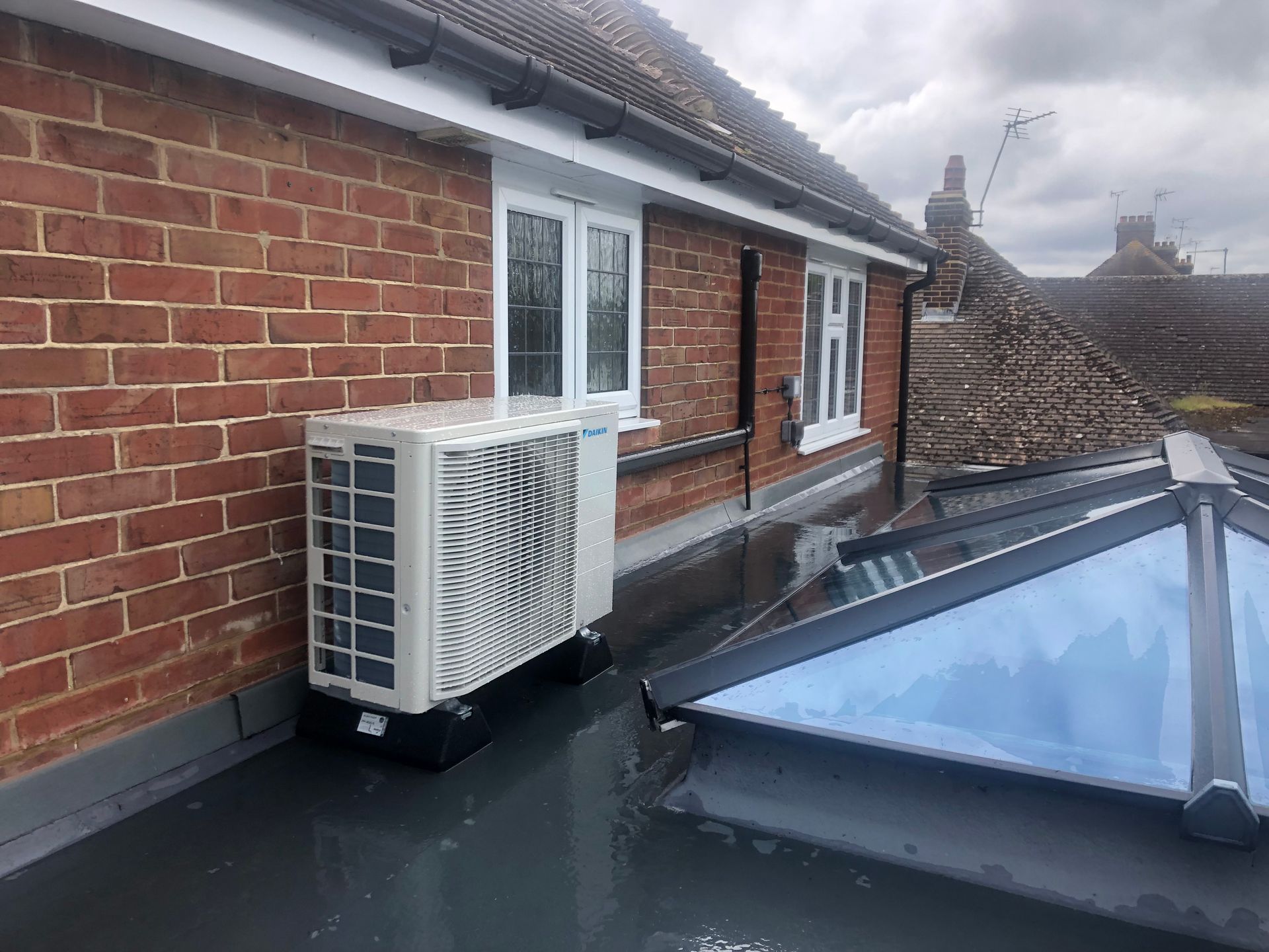 Condenser on antivibration feet located on a flat roof with neat clean trunking