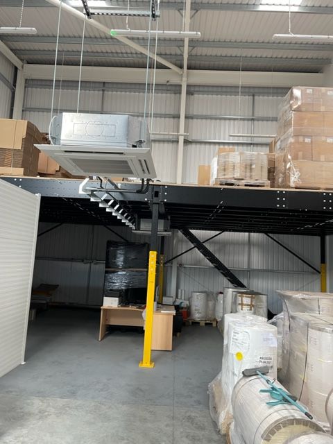 Warehouse storage area with mezzanine, has air conditioning installed with a neat and intricate routing for the services.