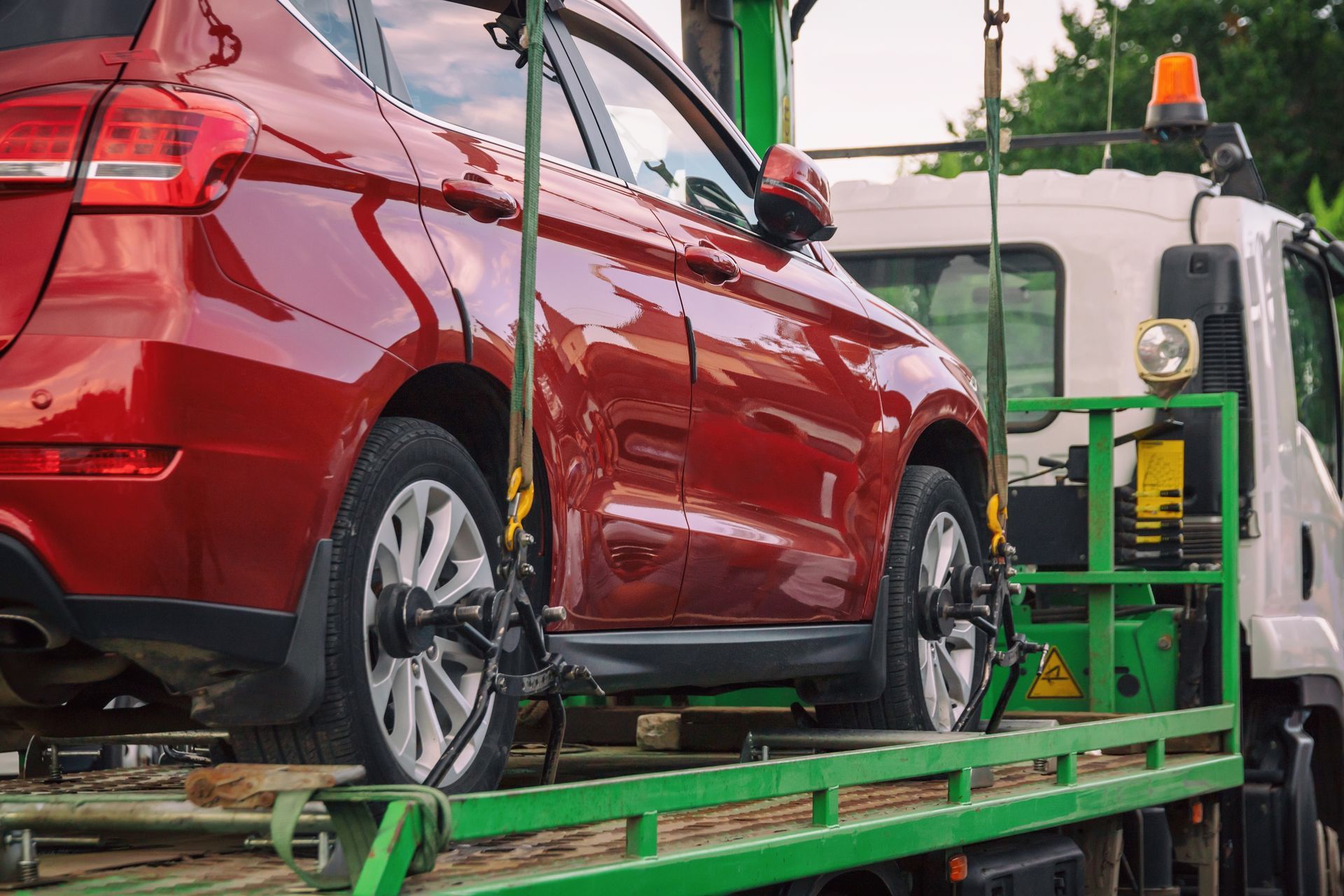 Red Car Being Towed by a Tow Truck — Penfold Towing in Dundowran Beach, QLD