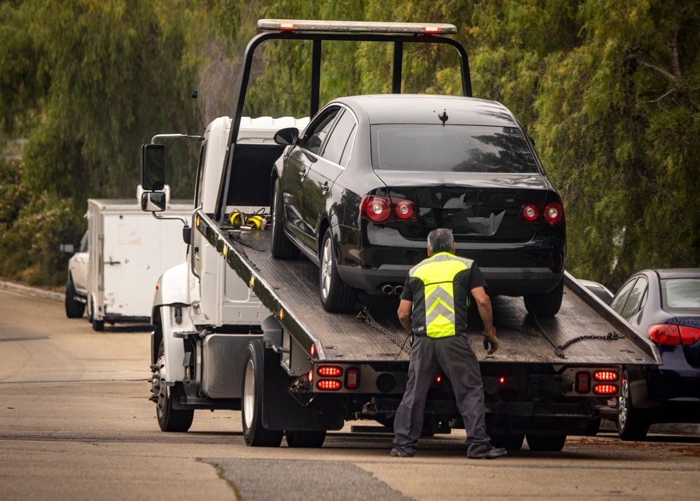 Tow Truck Loading a Black Car on a Road, Tow Truck Operator — Penfold Towing in Urangan, QLD