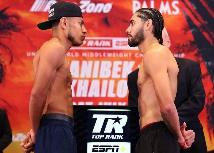 Two boxers face off at a weigh-in on a stage with Top Rank and ESPN logos.