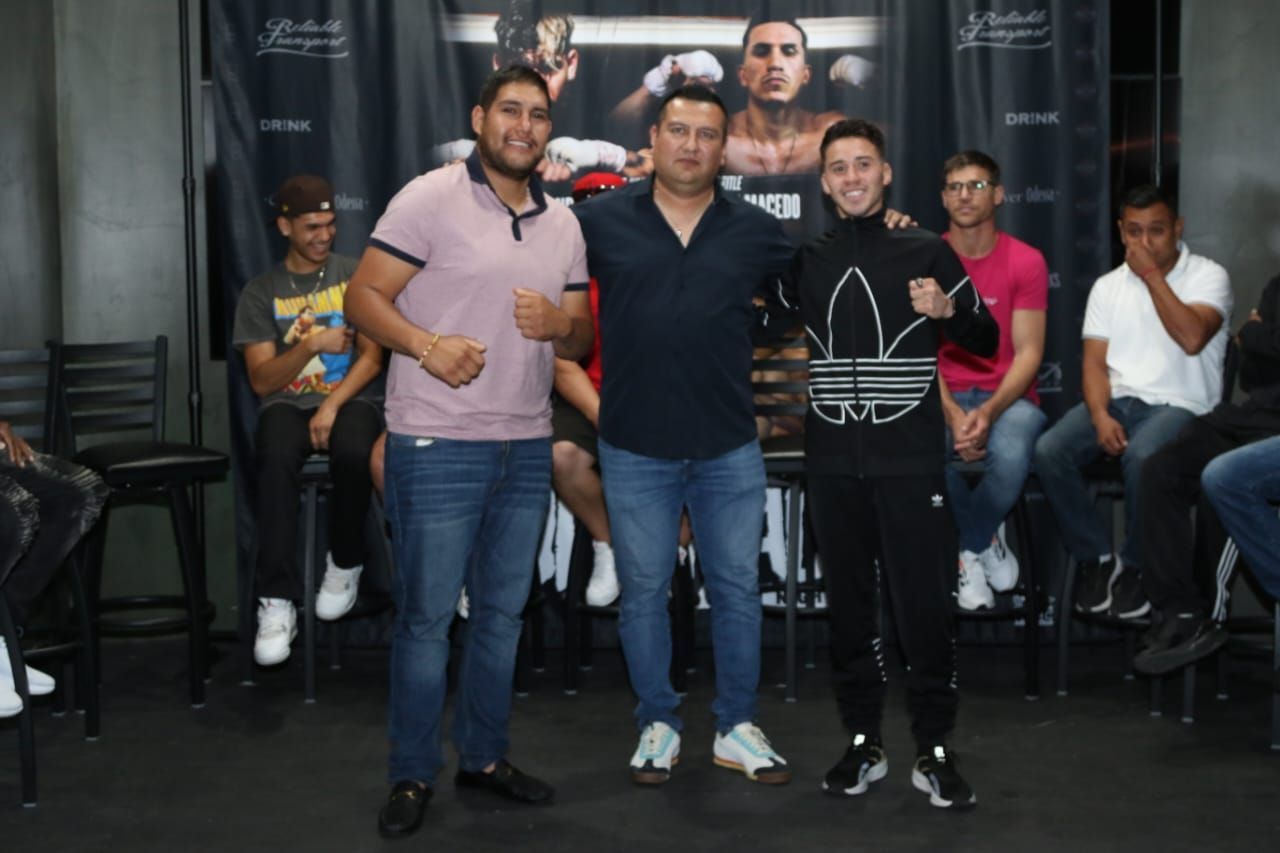 Group of friends posing indoors, smiling and holding drinks in a casual party setting.