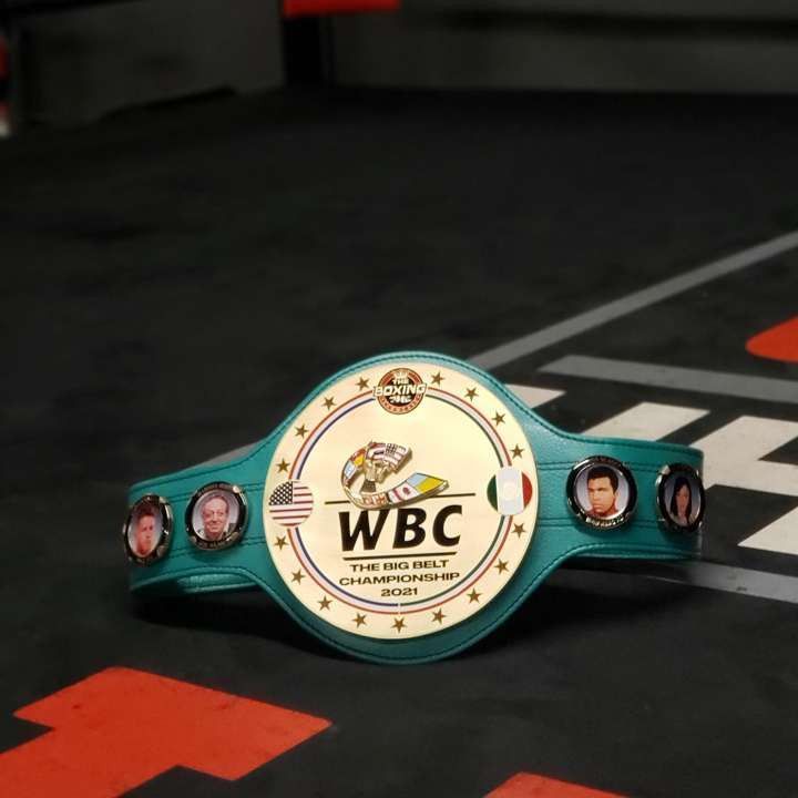 Teal WBC championship belt with gold center plate on a black surface with red and white markings