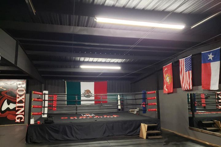 Boxing ring in a gym with Mexican and Texas flags on the walls.