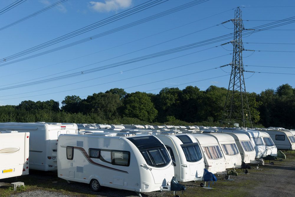 A Row Of Caravans Are Parked In A Lot With Power Lines — Hunter Valley Caravan Storage in North Rothbury, NSW