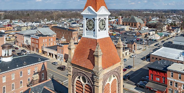 Aerial view of a town center with a red-roofed clock tower above surrounding buildings and streets