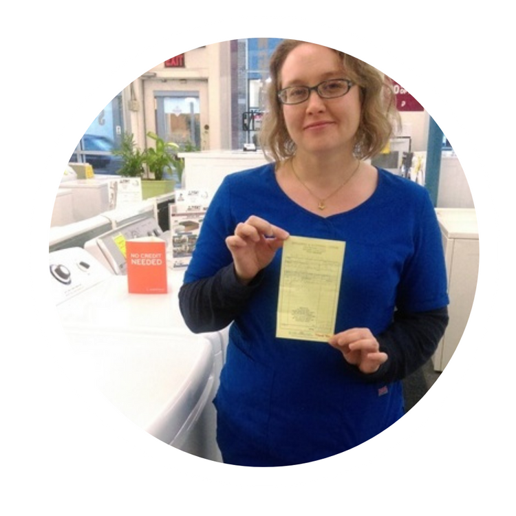 Woman in blue shirt holding a yellow receipt in a store checkout area