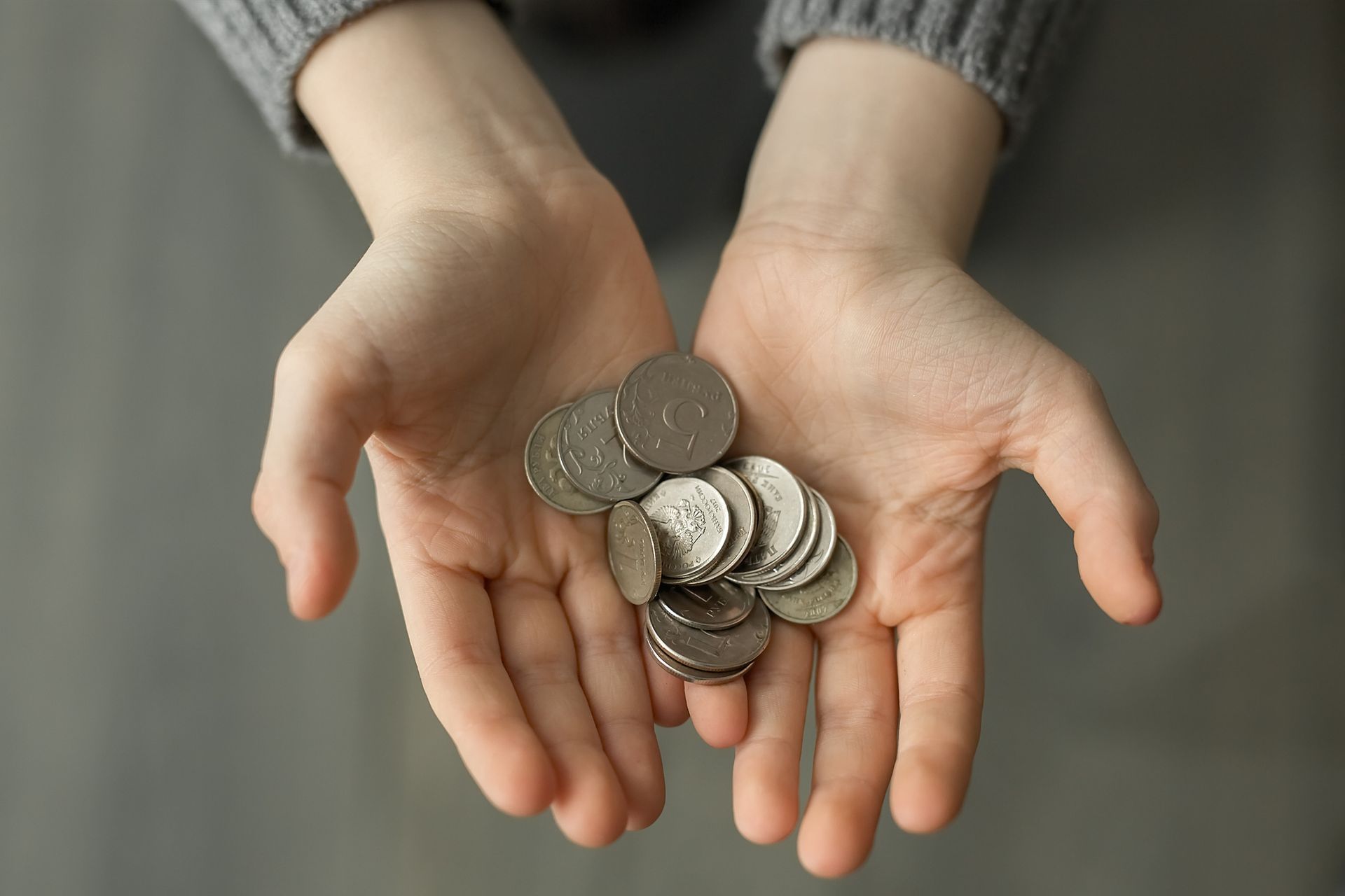 A couple of hands are holding coins. A couple of hands are holding coins.