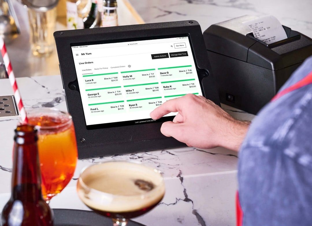 A person is using a tablet at a bar.