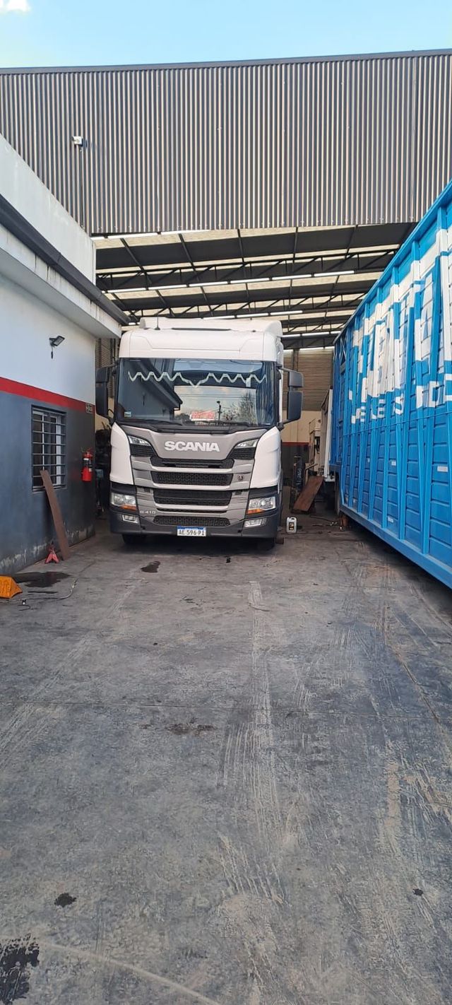 Engranajes metálicos, cojinetes y piezas de maquinaria industrial de diversos tipos dispuestos sobre una superficie desgastada.