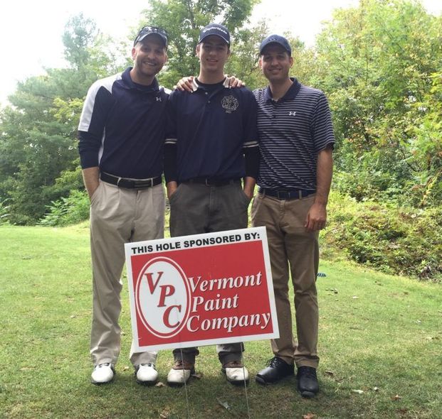 Three golfers stand on a green holding a Vernon Paint Company sponsor sign.