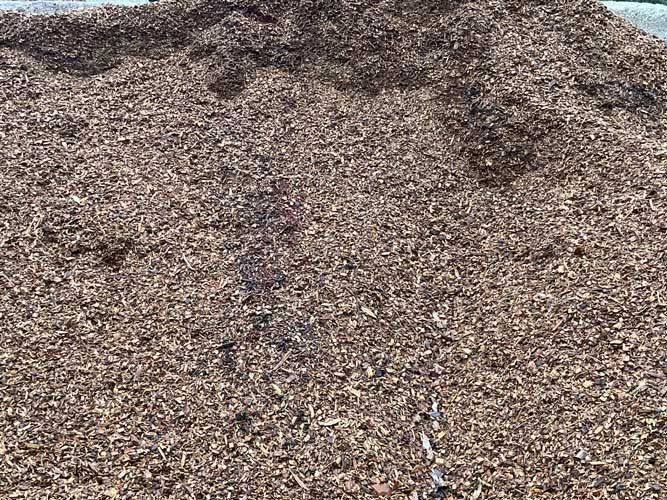 Close-up of a large gravel pile with a dark mound at the top edge
