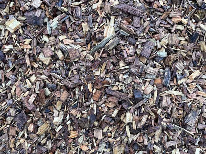 Close-up of mixed wood chips and bark mulch in brown, tan, and gray tones