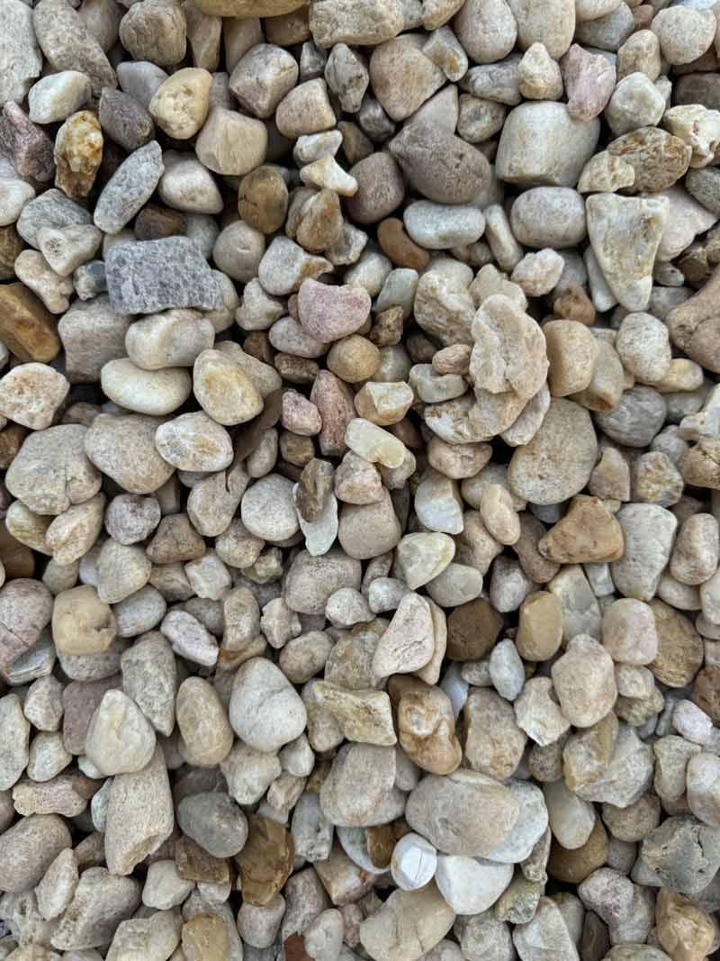 Close-up of small beige and gray pebbles filling the frame