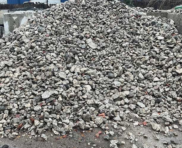 Large pile of gray rubble and broken concrete on a construction site