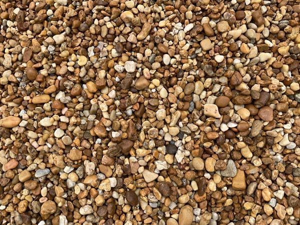 Close-up of small tan, brown, and white pebbles covering the ground.