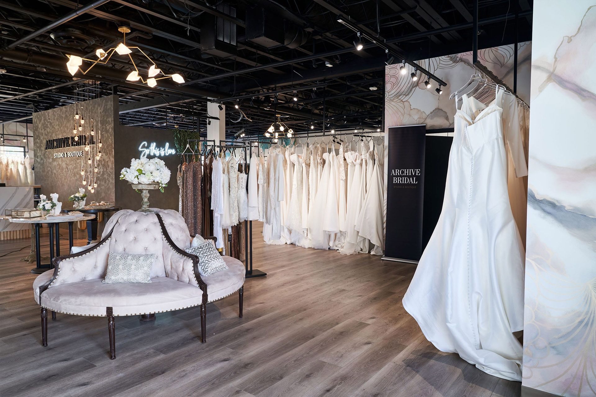 A room filled with lots of white dresses and a couch.