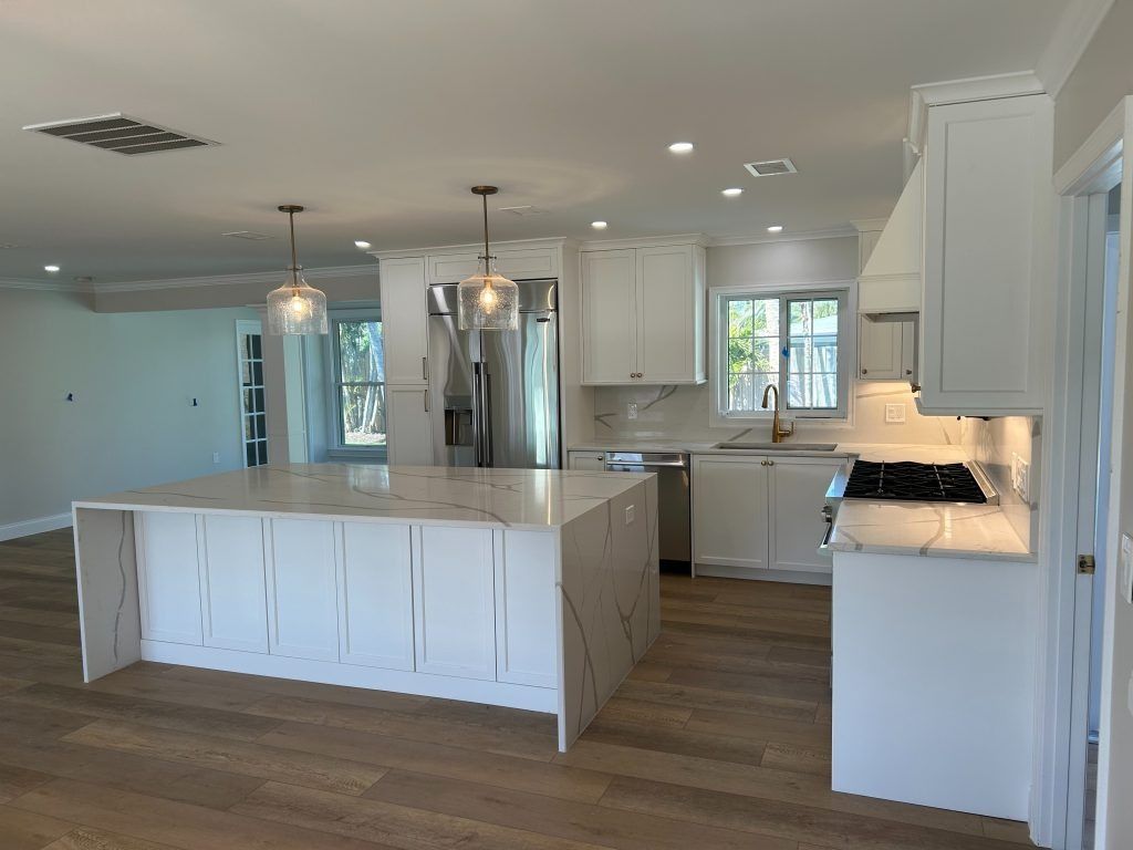 Modern white kitchen with island, cabinets, and appliances.