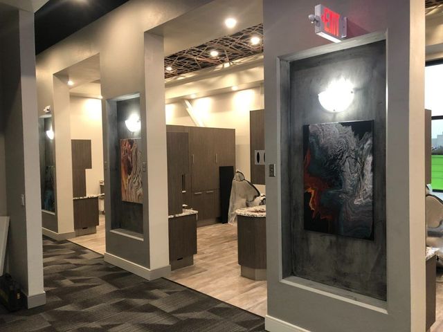 Hallway with artwork niches, cabinets, recessed lighting, and a dark carpet.