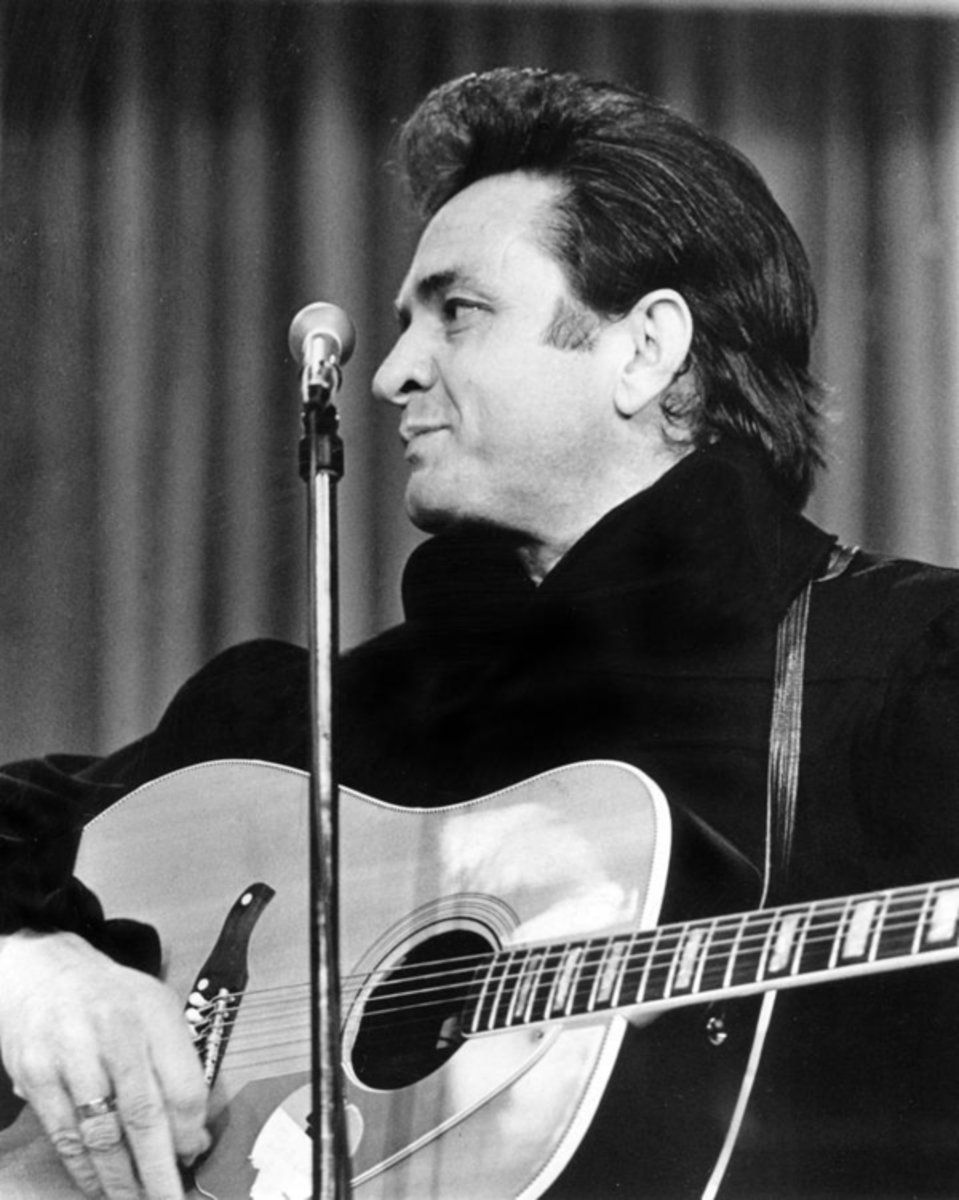 A man playing a guitar in front of a microphone