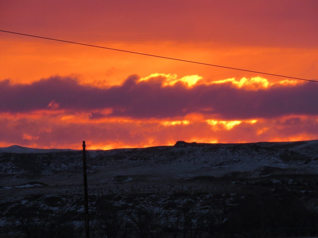 A sunset with a telephone pole in the foreground