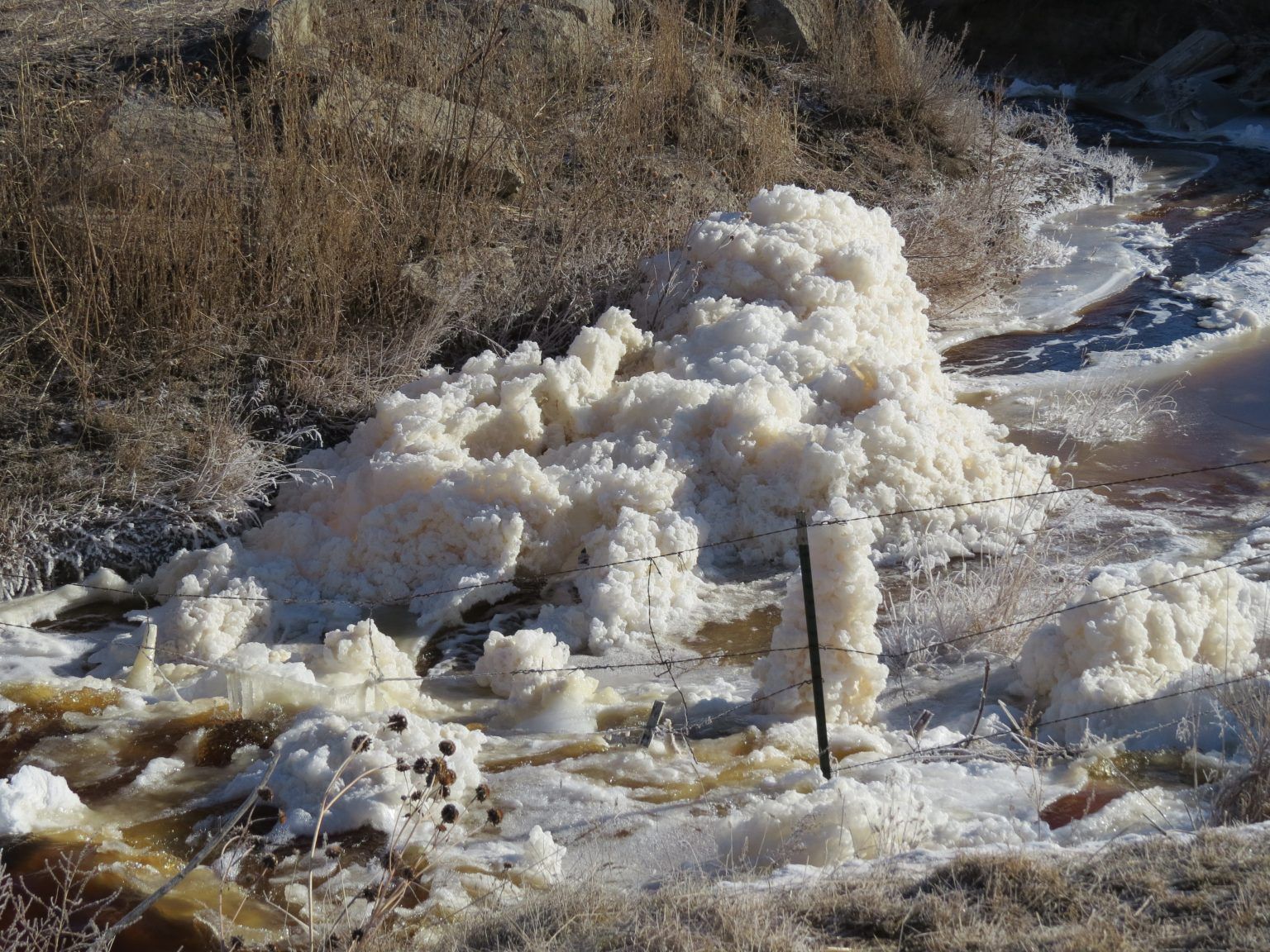 A pile of snow is sitting in the middle of a field