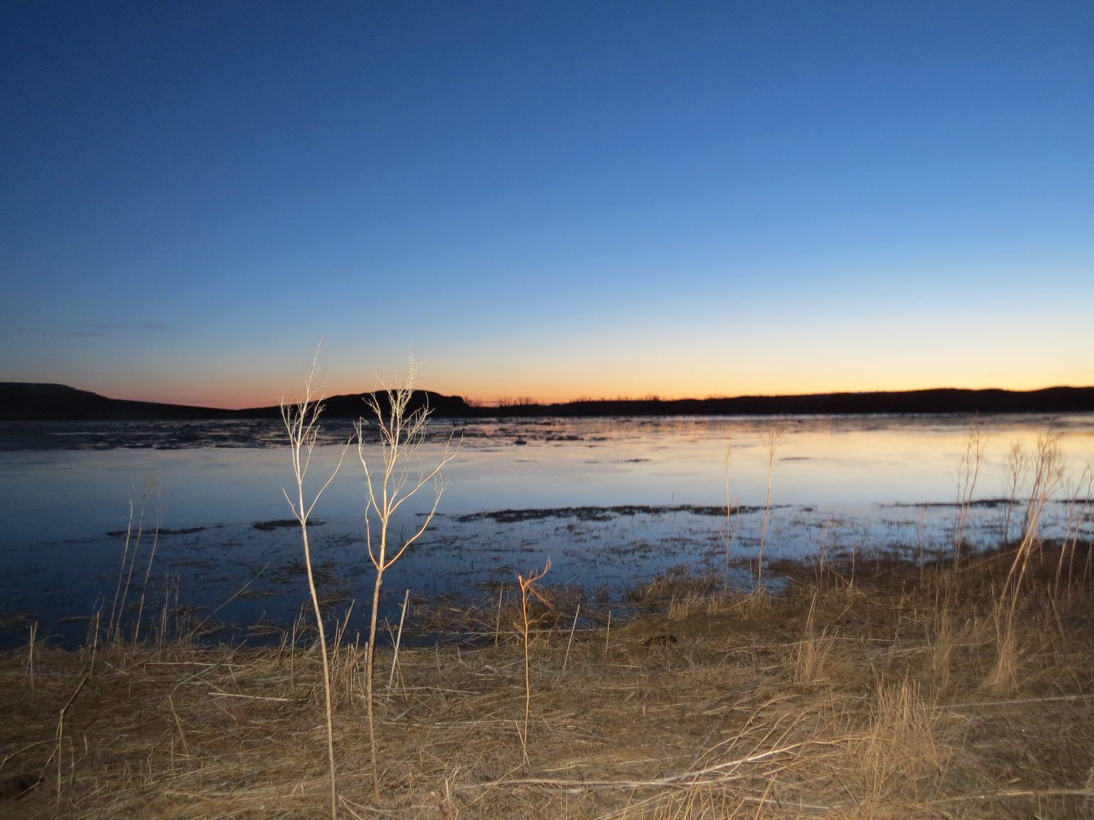 A large body of water with a sunset in the background