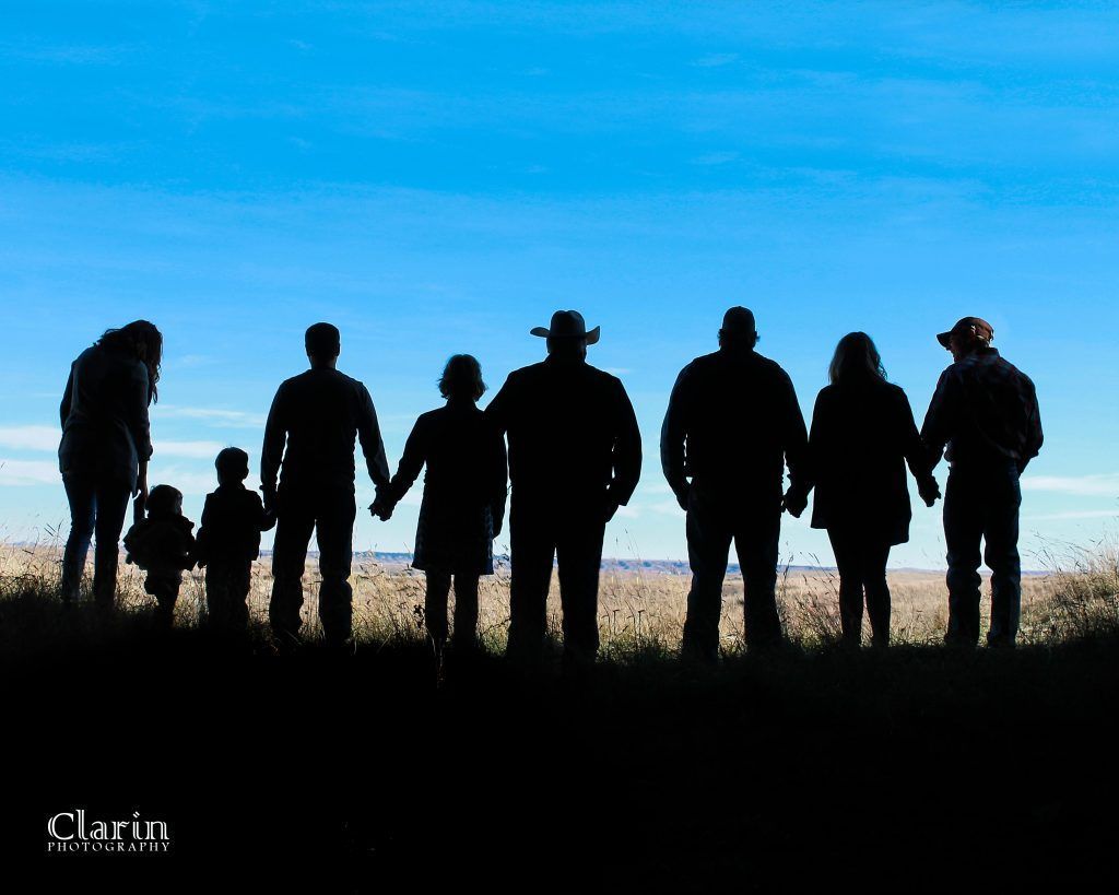 A group of people standing in a field holding hands