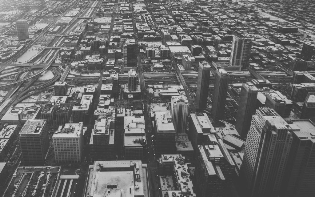 An aerial view of a city with lots of buildings in black and white.