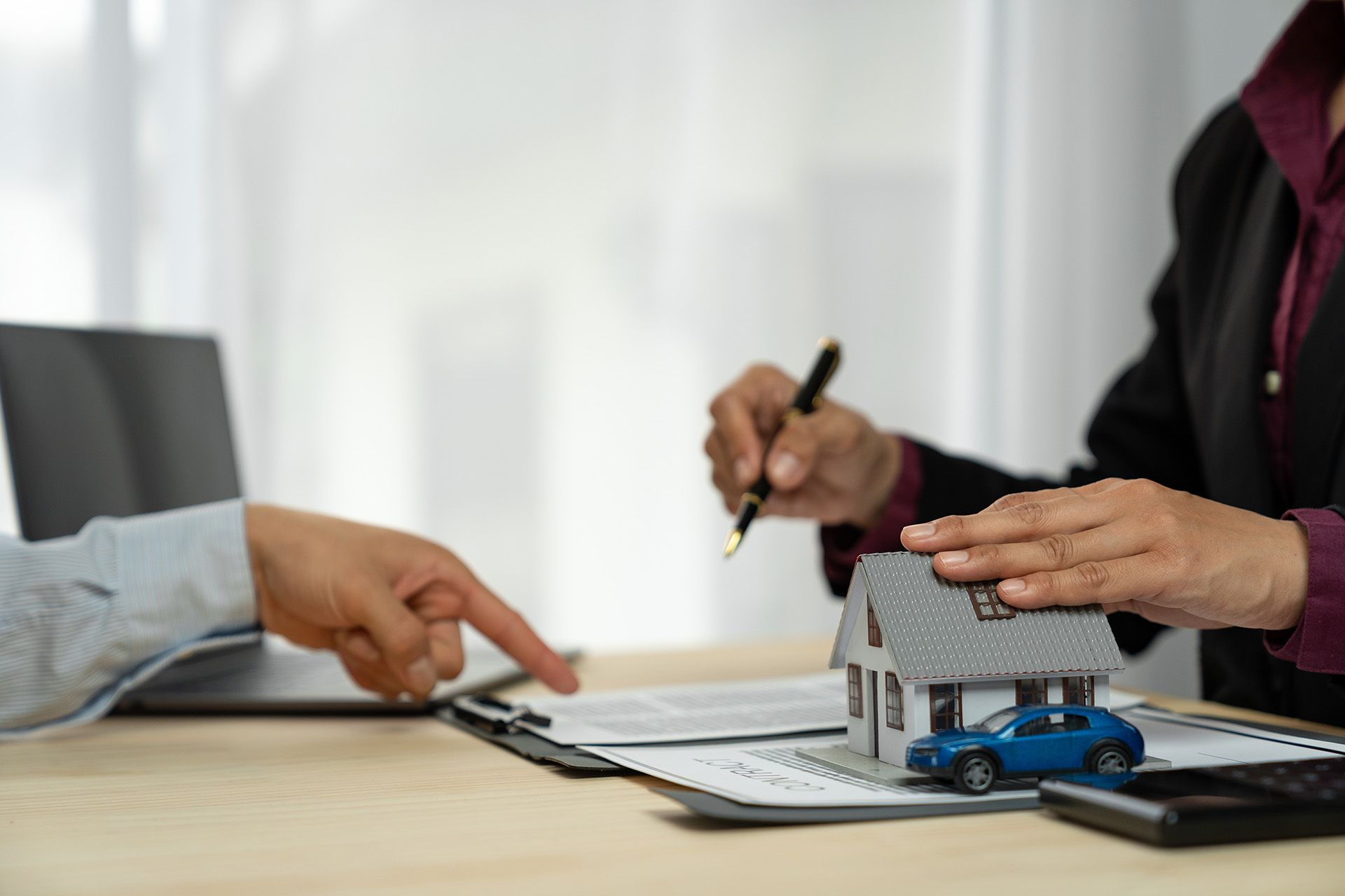A person consulting with a home insurance agency to finalize a comprehensive policy for a house. A person consulting with a home insurance agency to finalize a comprehensive policy for a house.
