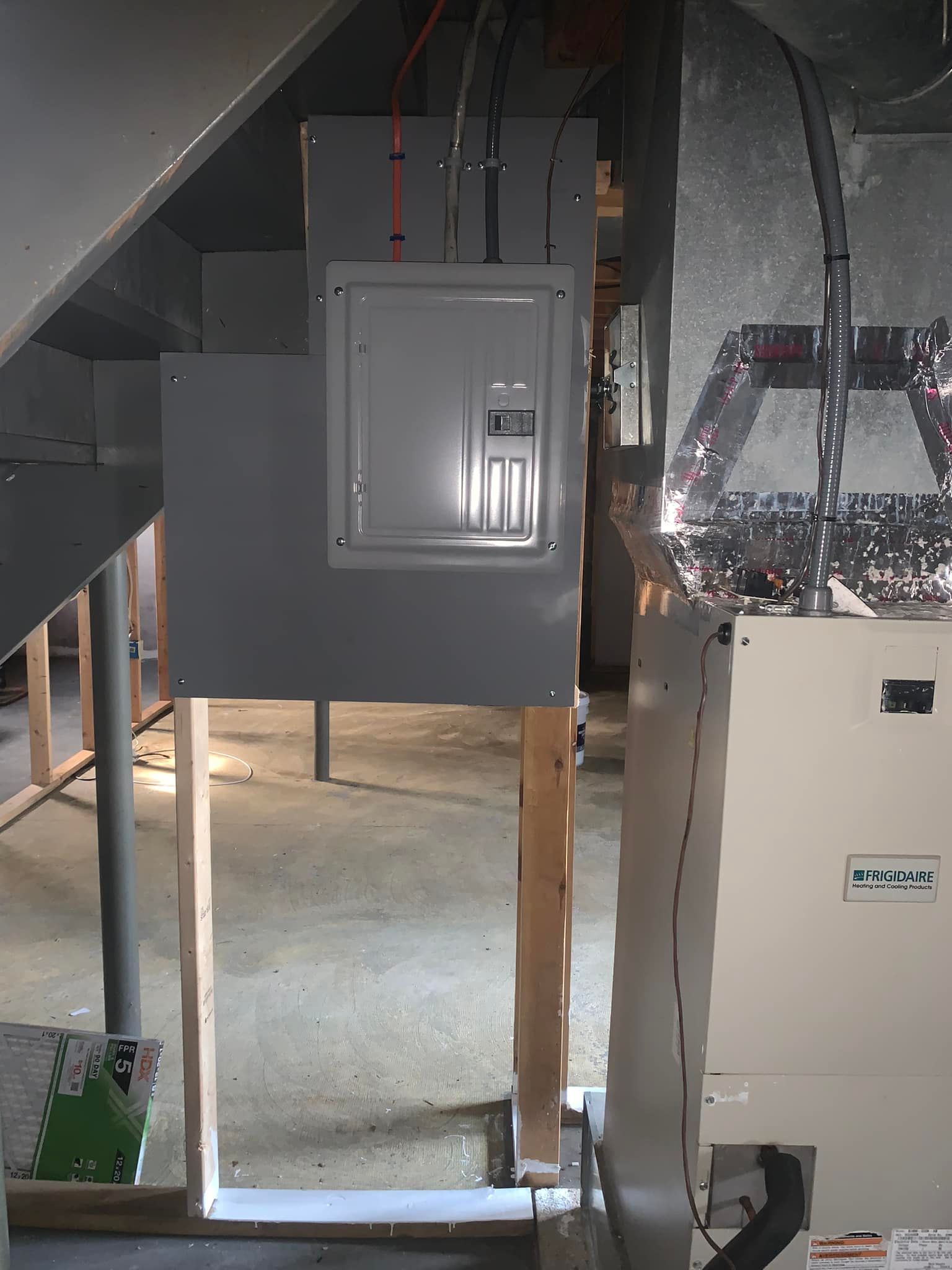 A room with a staircase and a box that says ' electrical ' on it