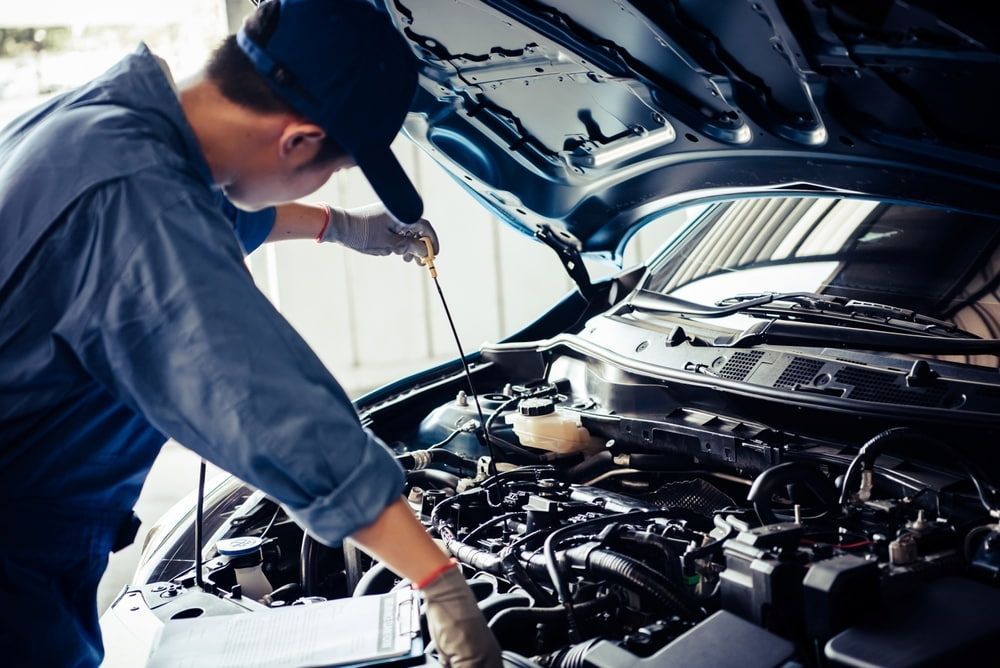 Mechanic Checking Car Engine Oil With a Dipstick Under the Hood — Nova Auto Innovations in Charlestown, NSW
