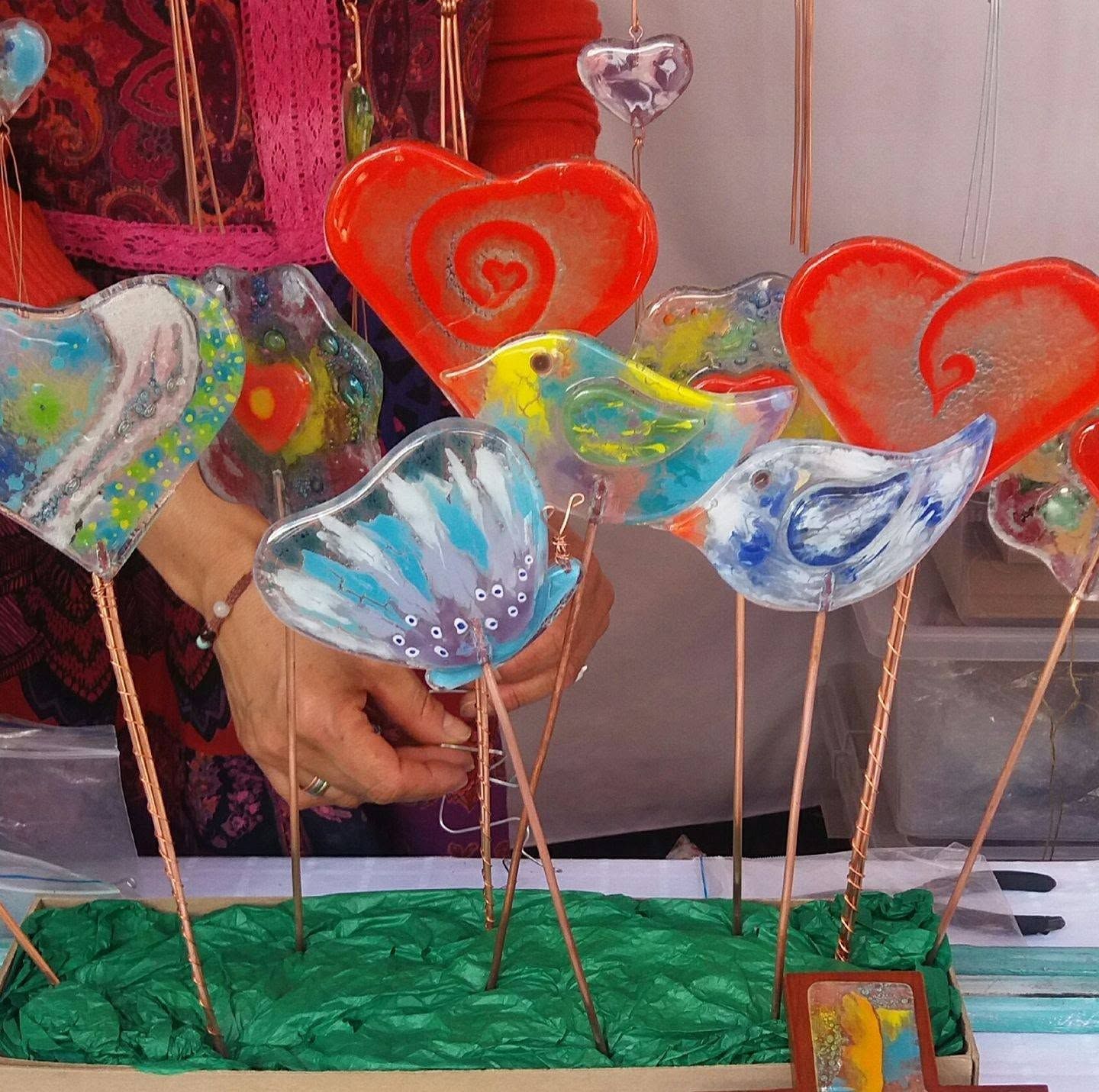 Decoraciones coloridas de corazones y conchas de vidrio hechas a mano sobre palitos en un puesto del mercado