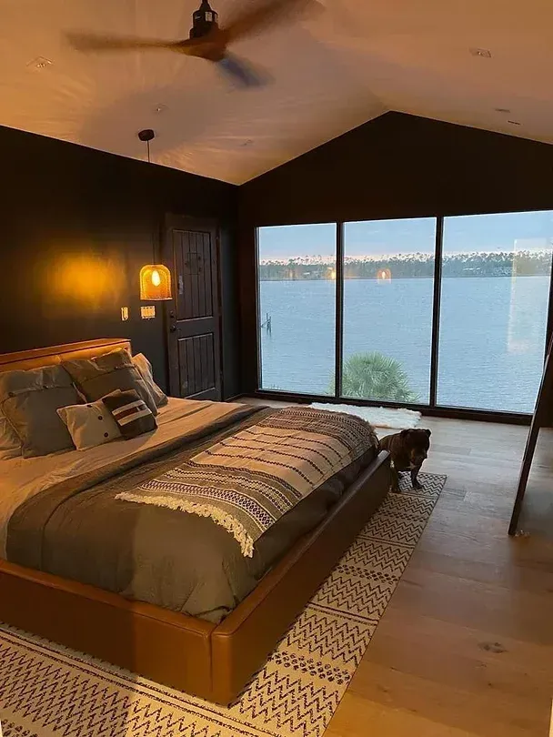 A bedroom with a large bed and a view of the water.