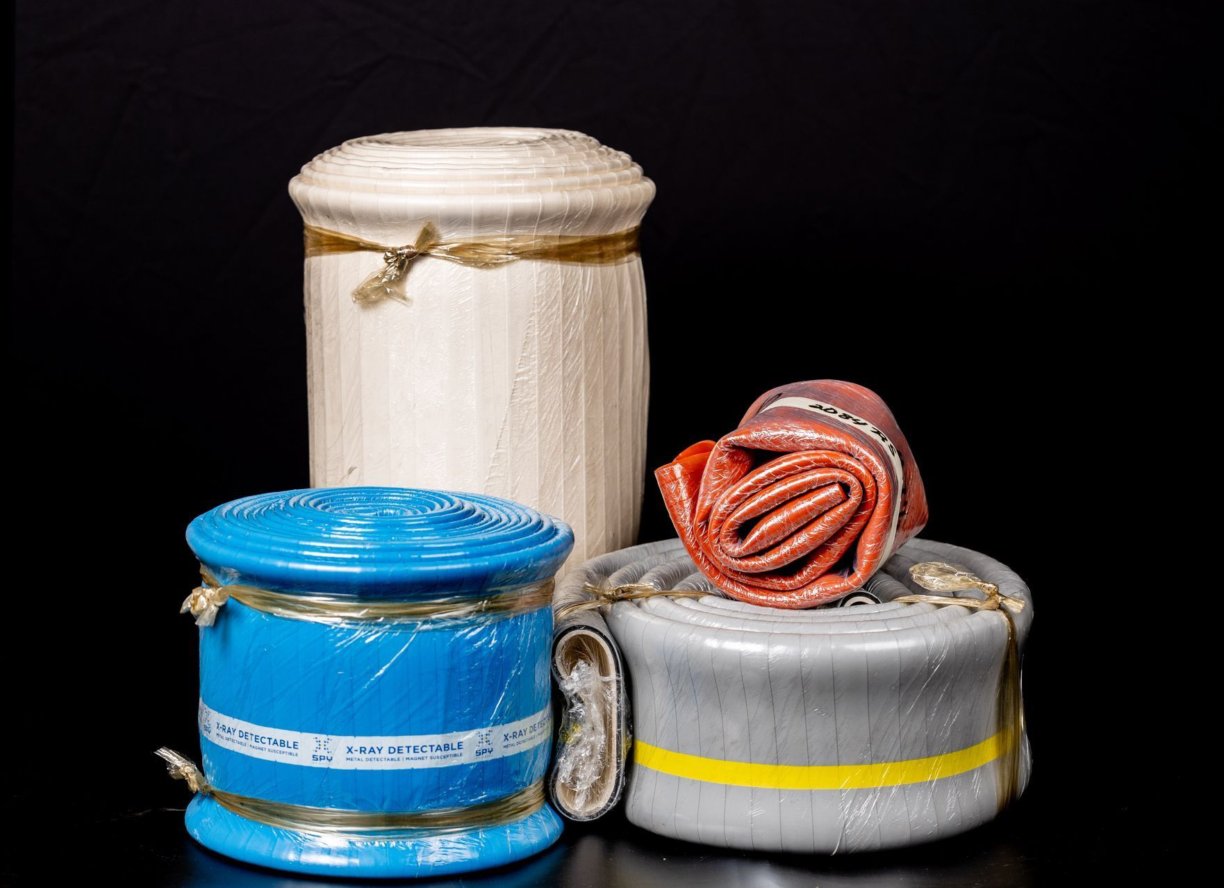 Four colorful coiled ropes with wrapped ends, arranged on a black background.