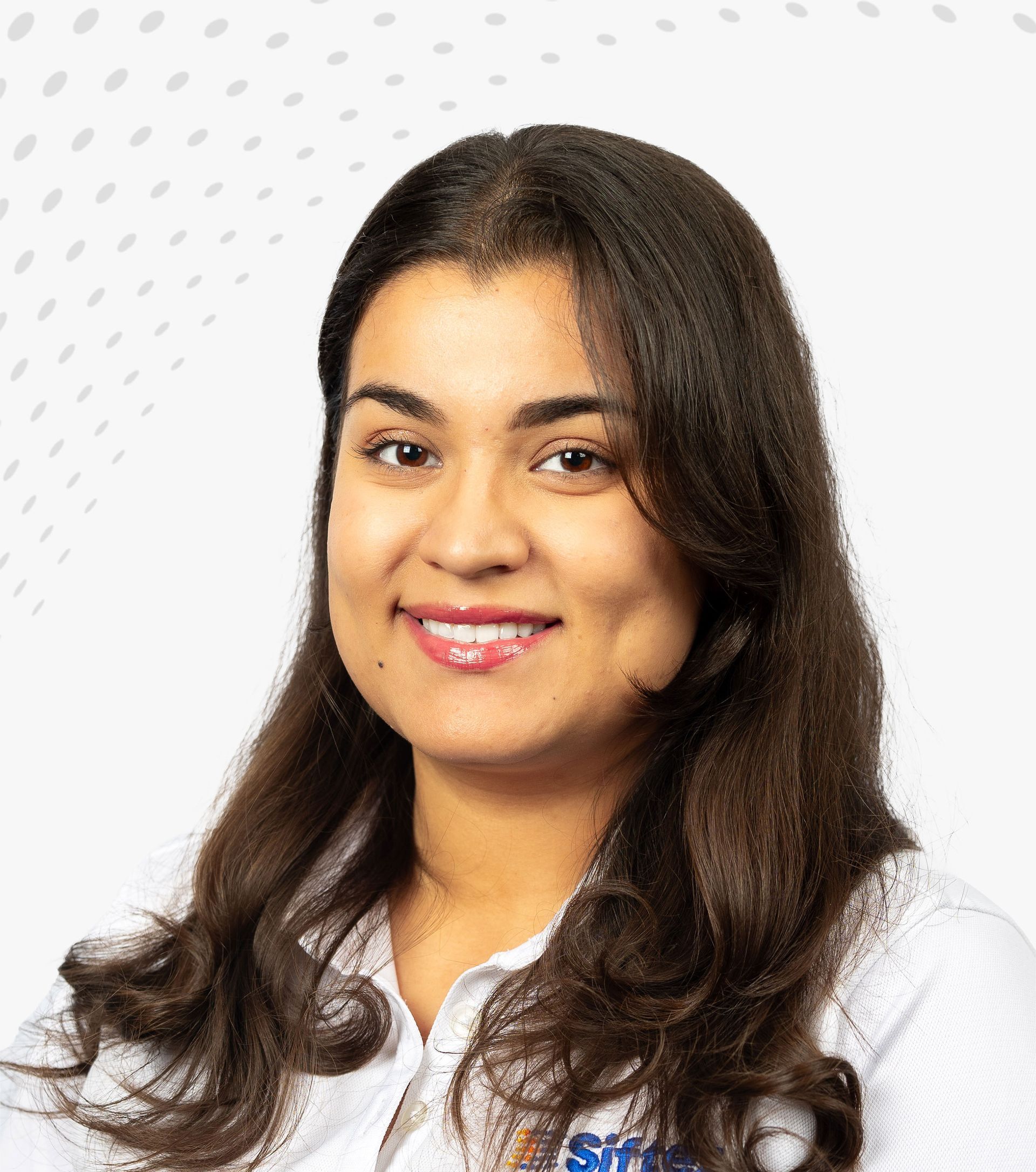 Smiling woman with long dark hair in a white blouse against a light gray background