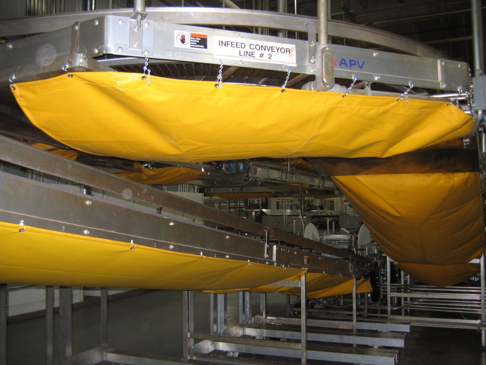 Large yellow industrial ducts or bags suspended in a metal facility interior