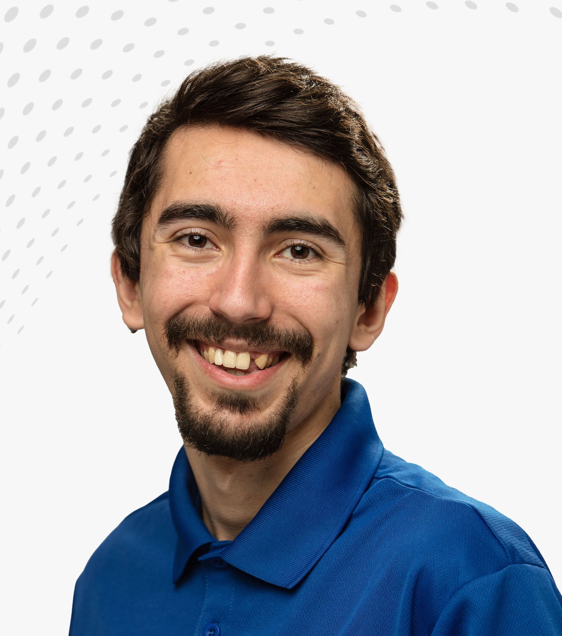 Smiling man in a blue shirt against a white patterned background