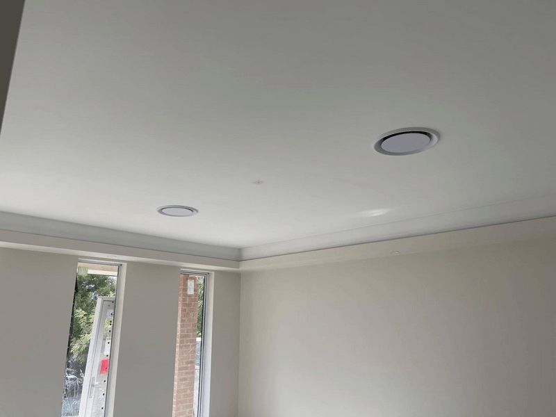 A room with white walls and a white ceiling with two lights on it.