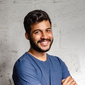 a man with a beard wearing a blue shirt is smiling