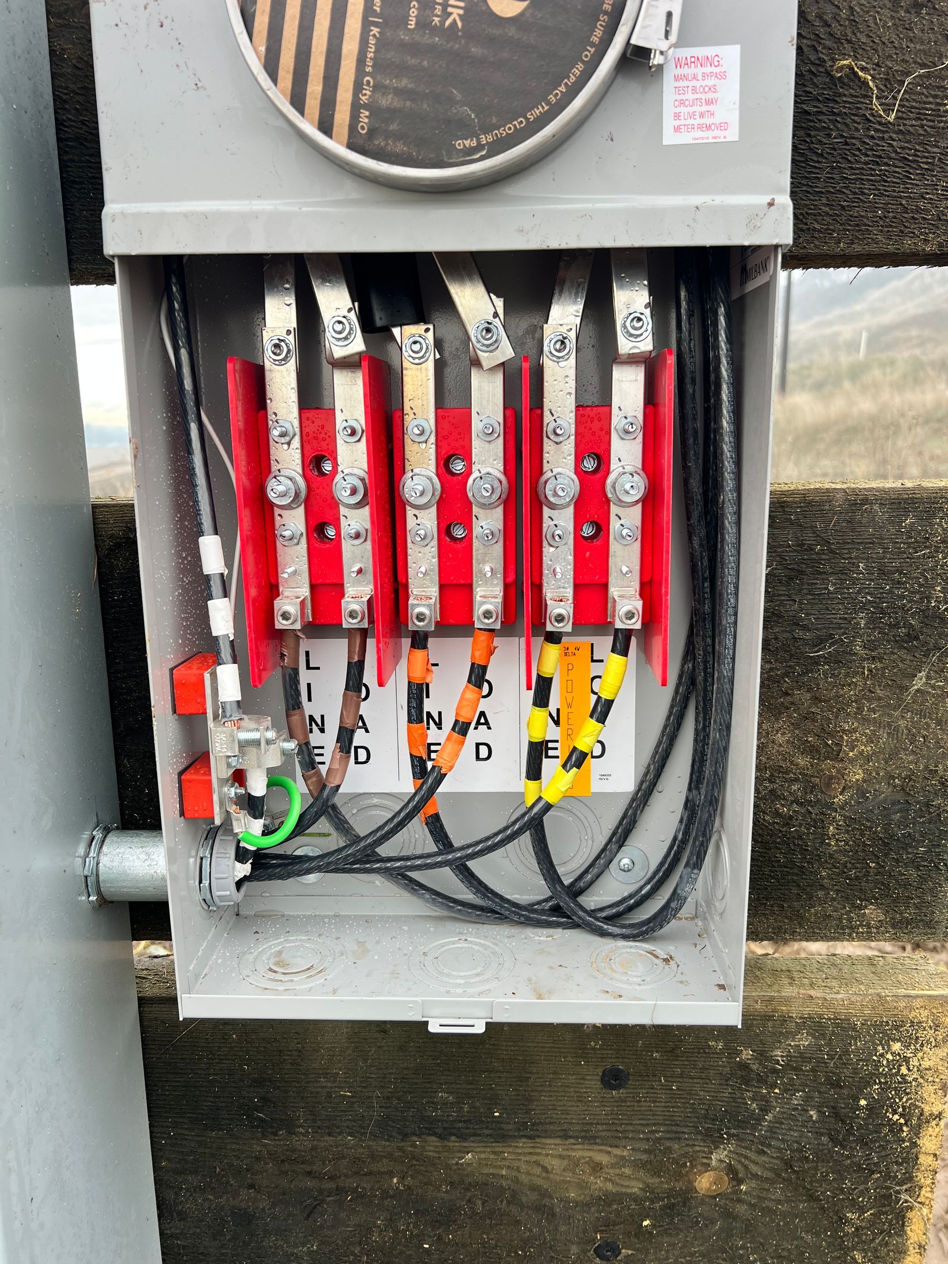 Open electrical panel with red breaker switches and bundled wires.