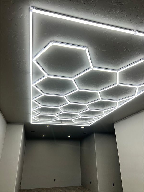 Modern room with glowing hexagonal ceiling lights and recessed spotlights