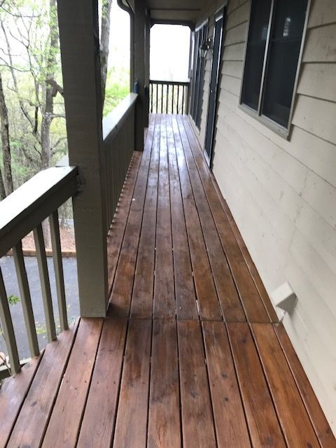 Wooden deck with two Adirondack chairs facing a backyard view in autumn